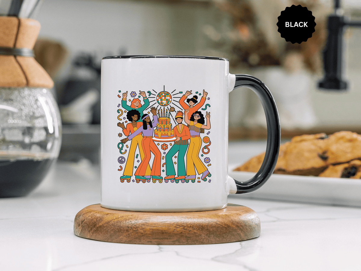 A white ceramic mug with a colored handle and interior, printed with six roller skaters in orange, teal, purple and mustard 70s outfits dancing around a tiered birthday cake under a disco ball.
