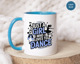 A white ceramic mug with a colored handle and interior, printed with "JUST A GIRL WHO LOVES TO DANCE" in black and blue lettering with blue ballet shoes, music notes and a ballerina silhouette.