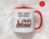 A white ceramic mug with a colored handle and interior, printed with "HOT MESS EXPRESS" in cream and black lettering above a train covered in pink and red roses with bows, hearts and sparkles.