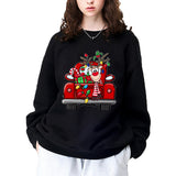 A black crewneck sweatshirt printed with a smiling reindeer riding in a red truck strung with Christmas lights.