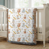 White fringed woven blanket printed with watercolour woodland animals in scarves, hedgehogs, squirrels, foxes and a deer, among acorns, small trees and yellow banners reading Johnny.