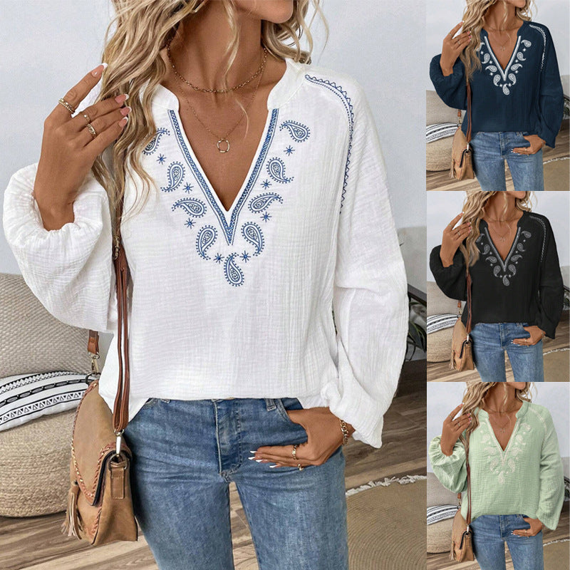 The same crinkle cotton blouse shown in four colourways, white, navy, black and sage green, each embroidered at the V neckline and shoulders with a blue paisley motif, each shown worn with blue jeans.