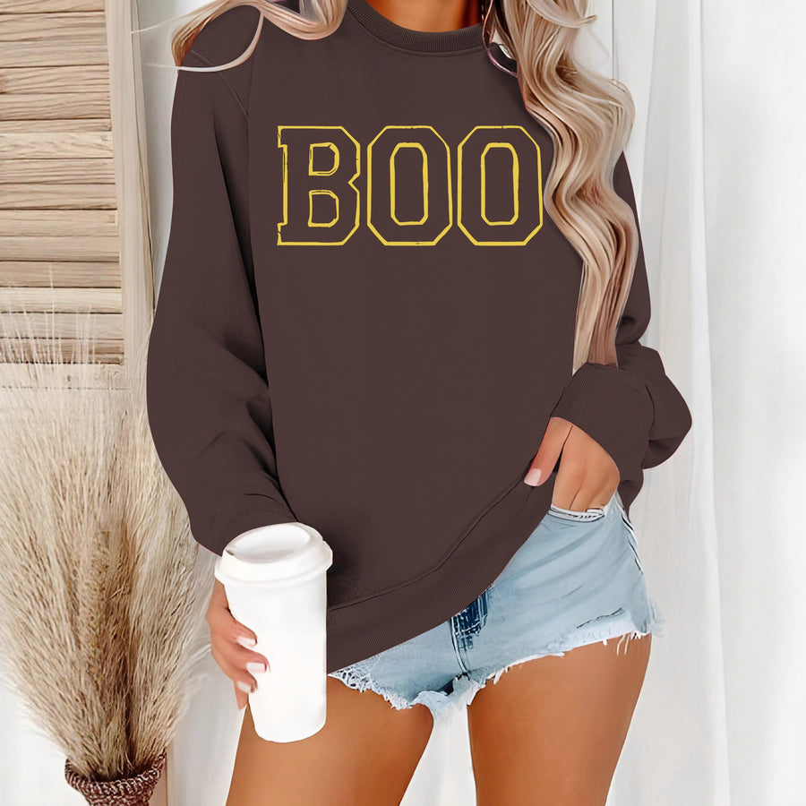 A cream crewneck sweatshirt printed with the word BOO in yellow outlined varsity letters.