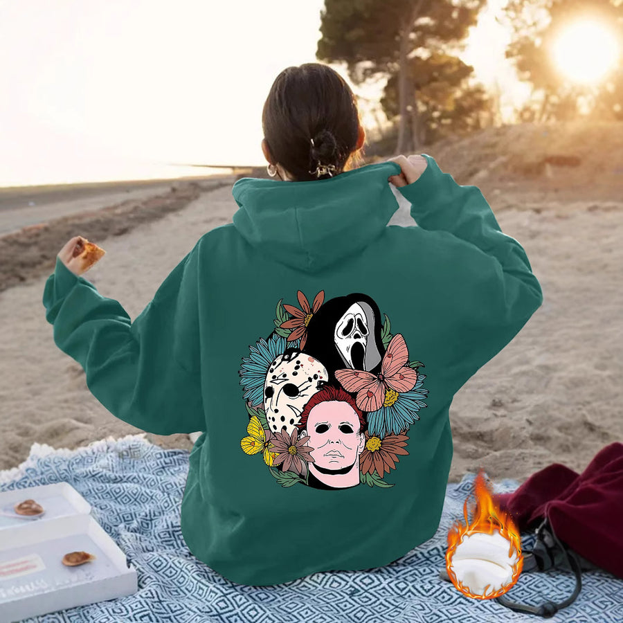 The back of a gray hoodie printed with three horror-movie masks surrounded by flowers and a butterfly.