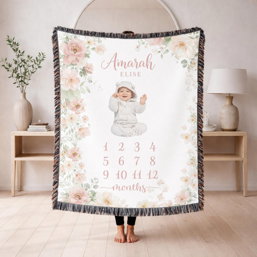 Fringed woven milestone blanket bordered with blush and cream watercolour roses and eucalyptus, printed with the name Amarah Elise and the numbers 1 to 12 beneath the word months.