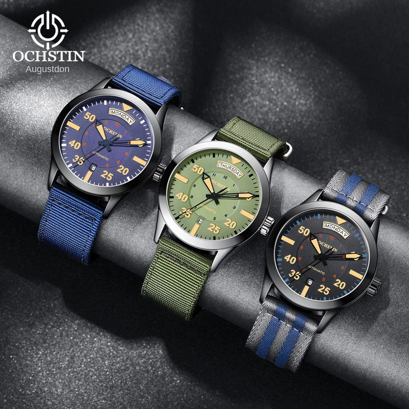 Black pilot style automatic watch with day and date windows and a striped nylon strap