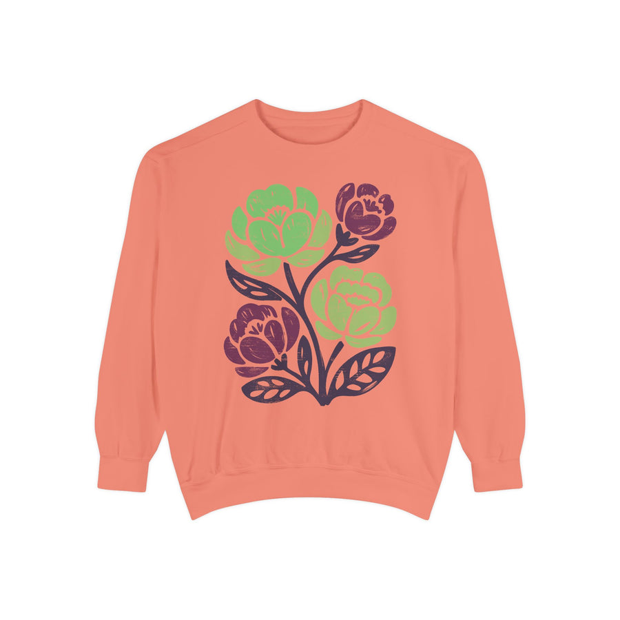Grey sweatshirt printed with block-print flowers in lime green and deep magenta on dark purple stems, the leaves outlined in the same purple with the rough texture of a hand-cut lino print.