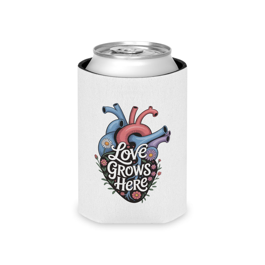 A white can cooler on a drink can, printed with "Love Grows Here" in white script on an anatomical heart in blue, red and purple, covered in daisies and small flowers.