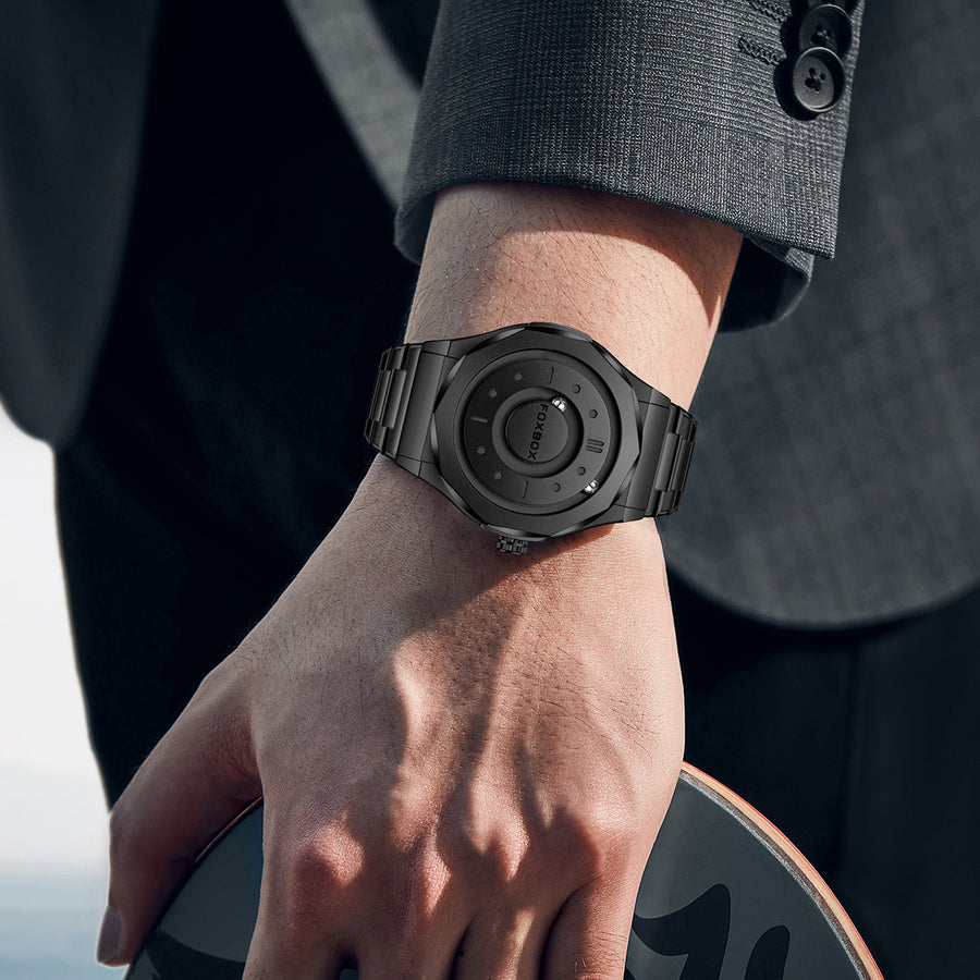 All-black FOXBOX watch with a rotating magnetic disc dial and stainless steel bracelet, close angled view