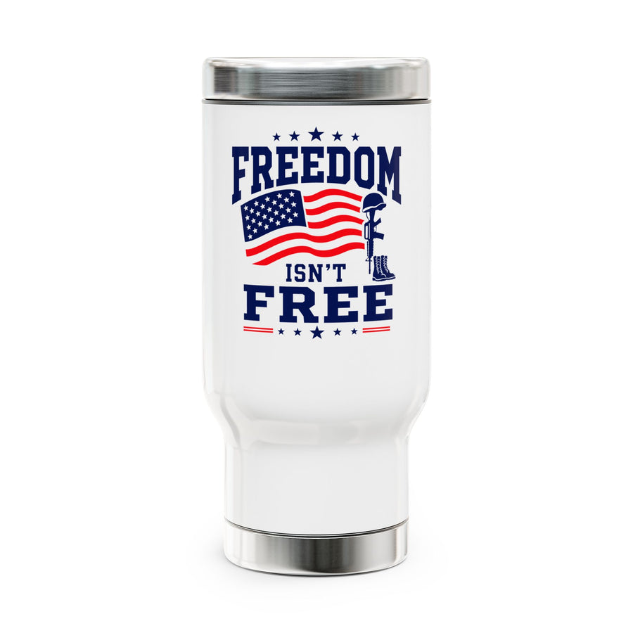 A white stainless steel travel mug with a silver lid and base, printed with "FREEDOM ISN'T FREE" in navy lettering around a waving American flag and a soldier's cross with helmet and boots.
