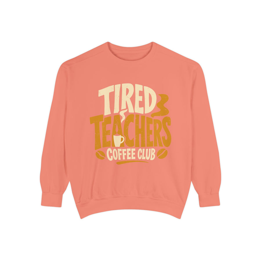 Pepper sweatshirt printed with the words Tired Teachers Coffee Club in chunky cream and gold lettering, a steaming mug set into the text and coffee beans scattered around.