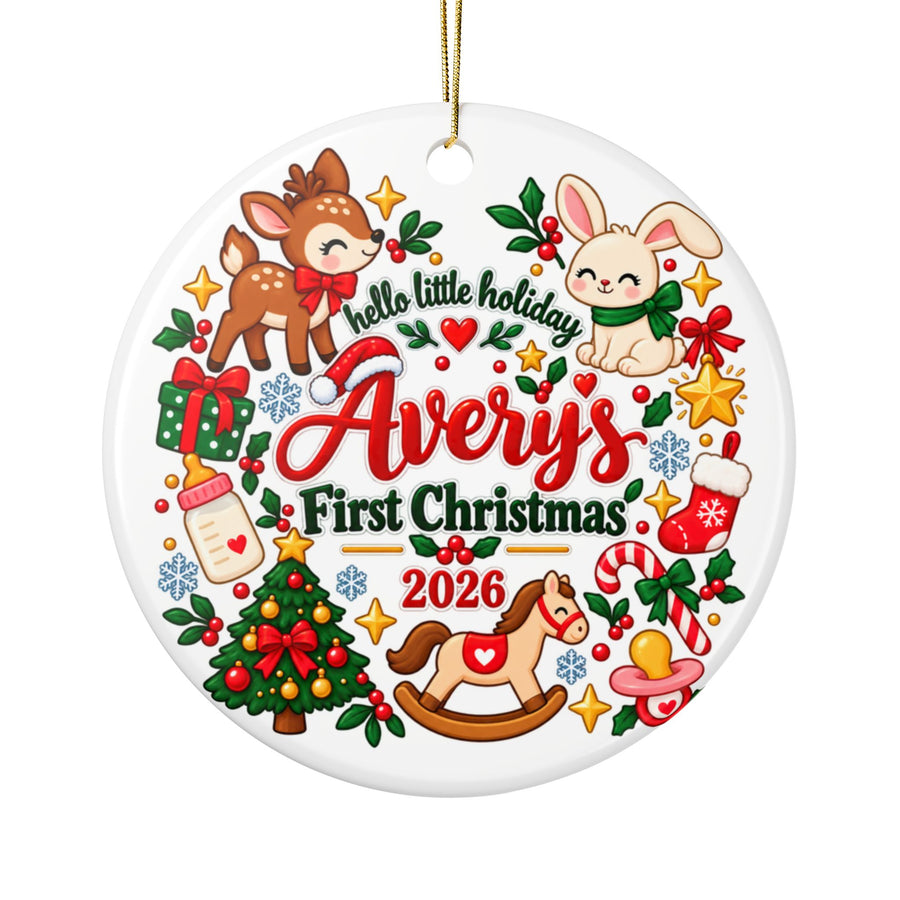 A round white ceramic Christmas ornament on a gold string, printed with "hello little holiday" and a sample baby name with "First Christmas" and "2026" in red and green lettering, ringed by a deer, a bunny, a rocking horse, a baby bottle, a stocking, a candy cane, a pacifier, a tree and a present.