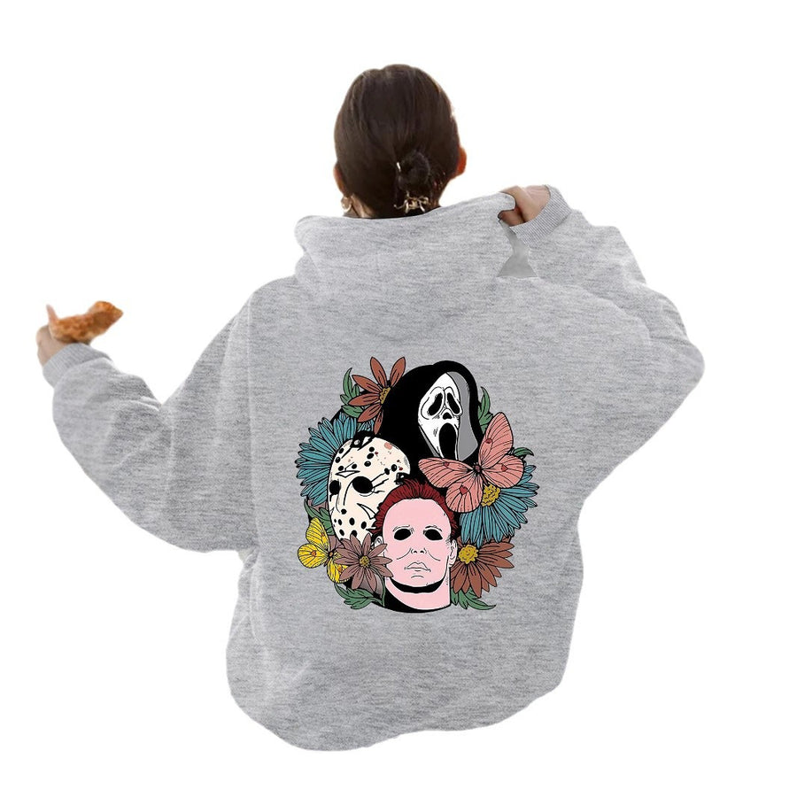 The back of a gray hoodie printed with three horror-movie masks surrounded by flowers and a butterfly.