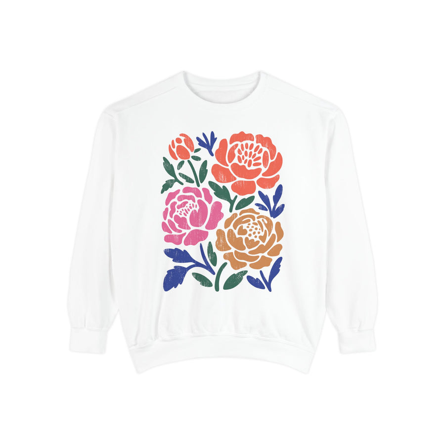 Chambray sweatshirt printed with four bold block-print roses in coral, pink and ochre, each bloom filled with fine line detail and framed by navy and dark green leaves and stems.