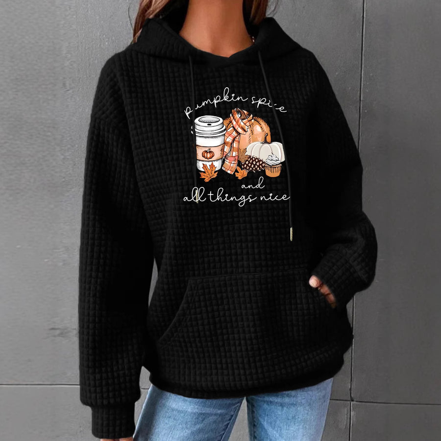 A black waffle-knit hoodie with a kangaroo pocket printed with a pumpkin spice latte, pumpkins and cozy fall items under pumpkin spice and all things nice.