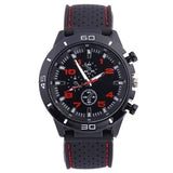 Black watch with red accents, chronograph-style dial and a perforated black silicone strap with red stripe