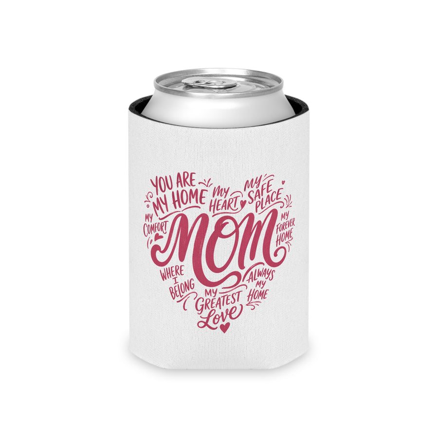 A white can cooler printed in pink script forming a heart shape with the word "MOM" and phrases like "my greatest love," holding a can, on a garden table.