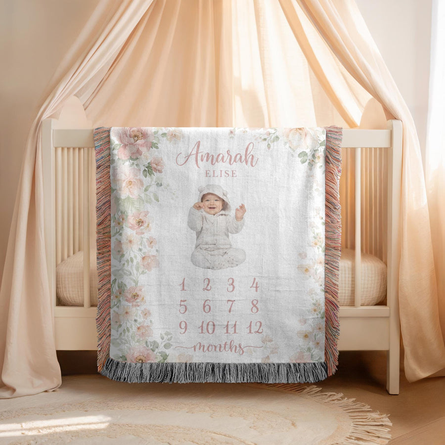 Fringed woven milestone blanket bordered with blush and cream watercolour roses and eucalyptus, printed with the name Amarah Elise and the numbers 1 to 12 beneath the word months.