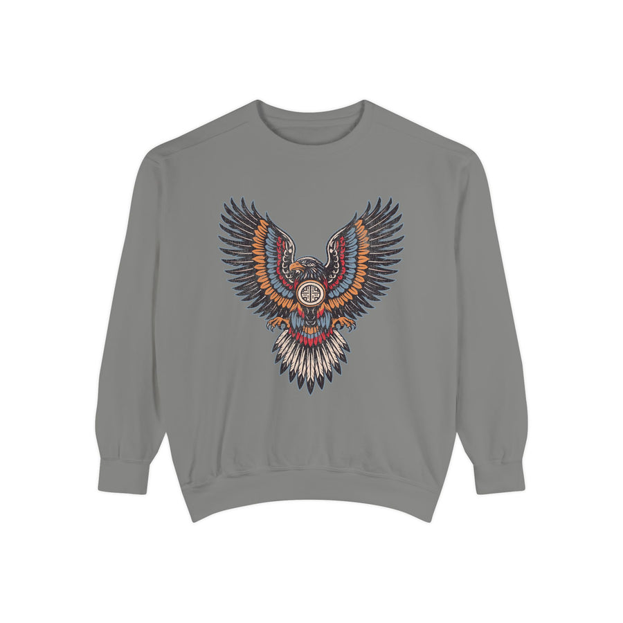 A pale yellow crewneck sweatshirt printed with an ornamental eagle with spread wings in red, blue and orange patterned feathers.