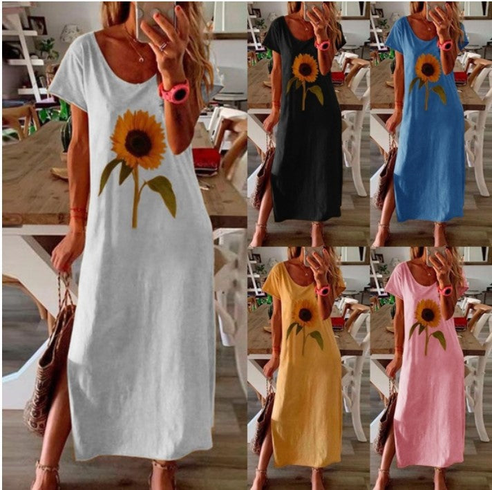 The same maxi dress shown in six colourways, white, black, blue, yellow and pink, each printed with one large sunflower and cut with a long slit at the side seam, each worn with a woven straw bag.