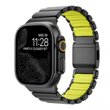 Black titanium link watch strap with yellow silicone inserts, fitted on an Apple Watch showing a topographic watch face