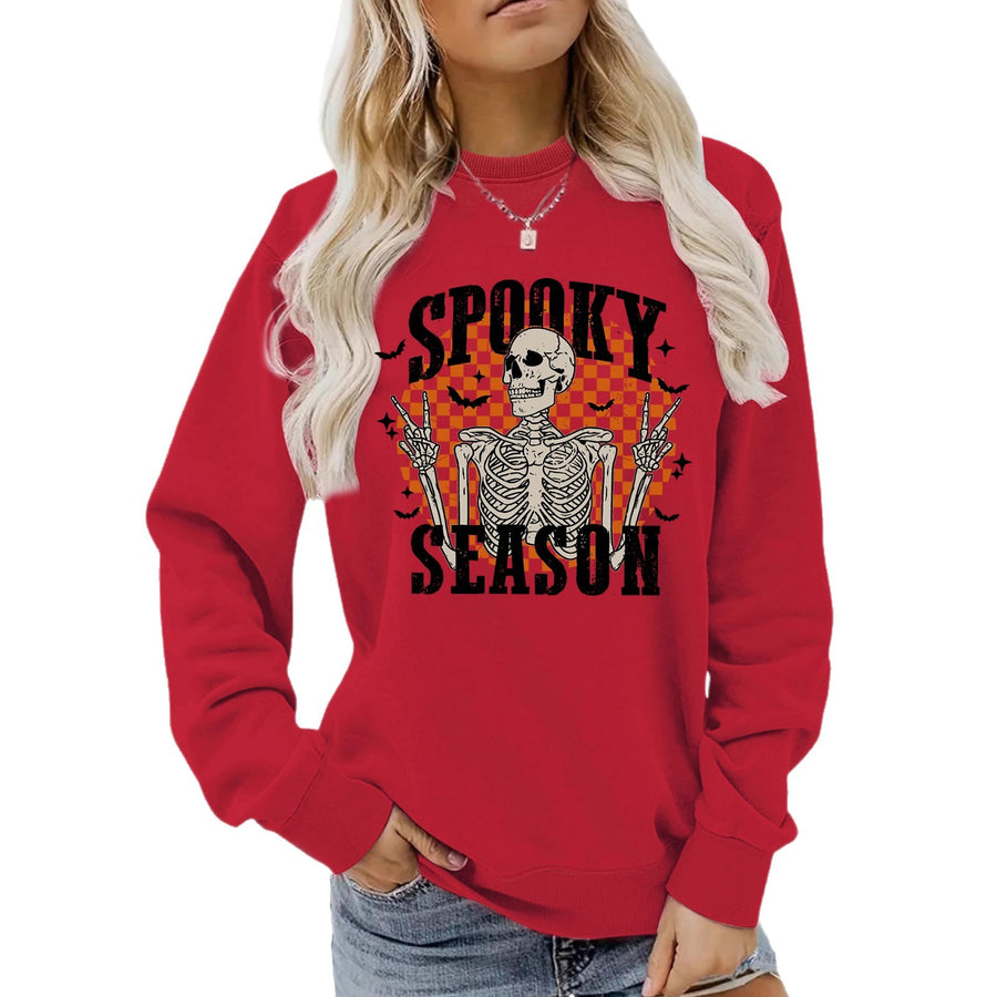 A red crewneck sweatshirt printed with a skeleton making peace signs in front of an orange checkerboard under the words Spooky Season.