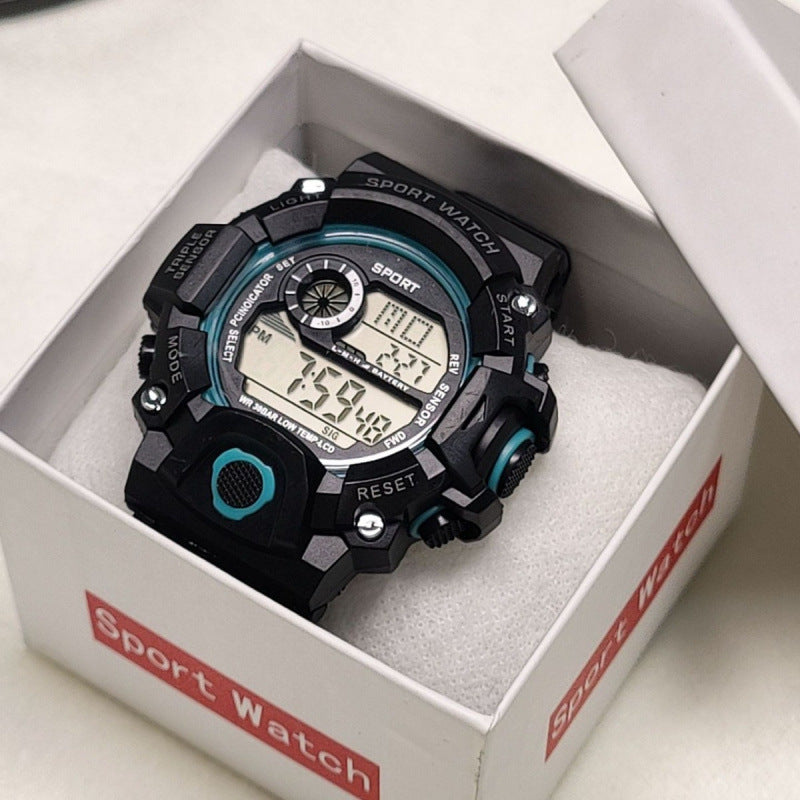 Black and teal kids digital sports watch with an LCD display, shown inside its retail packaging box