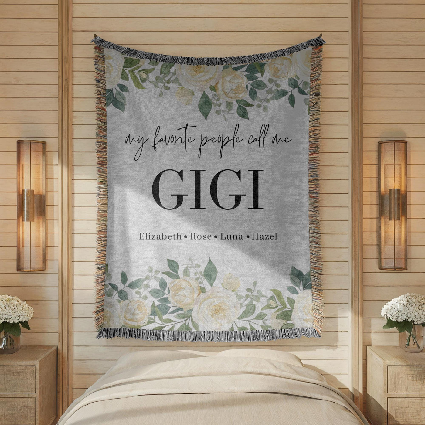 Grey fringed woven blanket printed with white roses and eucalyptus along the top and bottom, reading my favorite people call me Gigi above the names Elizabeth, Rose, Luna and Hazel.