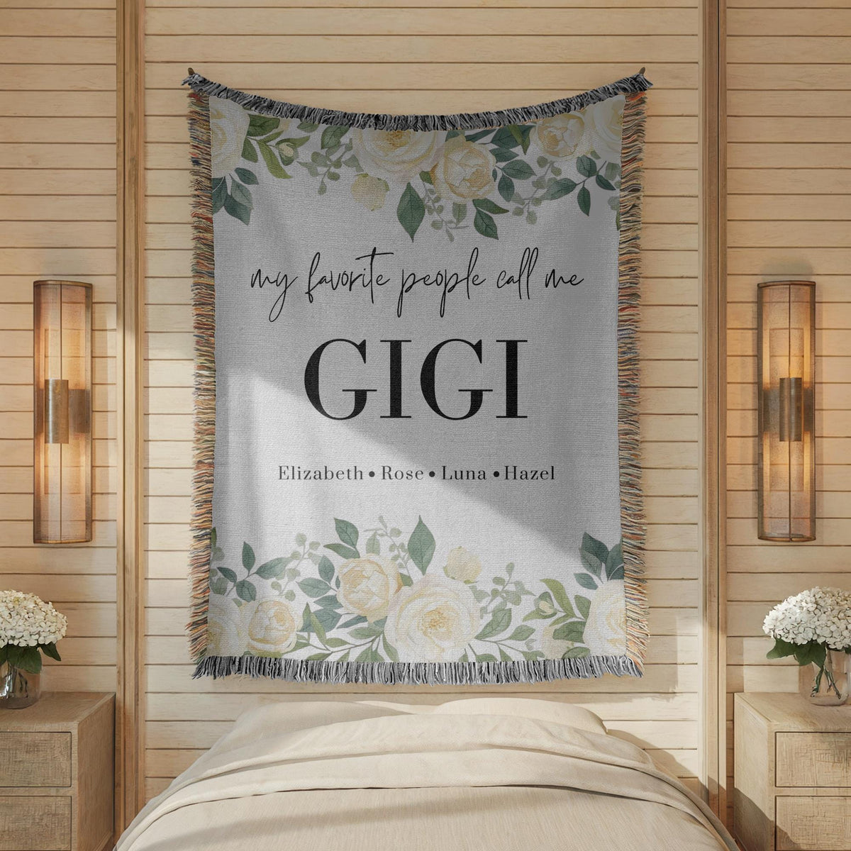 Grey fringed woven blanket printed with white roses and eucalyptus along the top and bottom, reading my favorite people call me Gigi above the names Elizabeth, Rose, Luna and Hazel.
