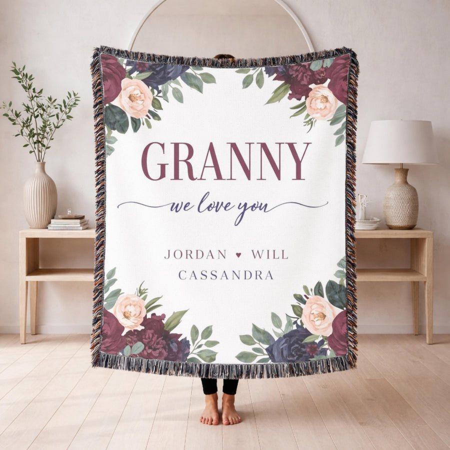 Grey fringed woven blanket with burgundy and blush peonies in the corners, reading Granny in tall letters above we love you in script and the names Jordan, Will and Cassandra.